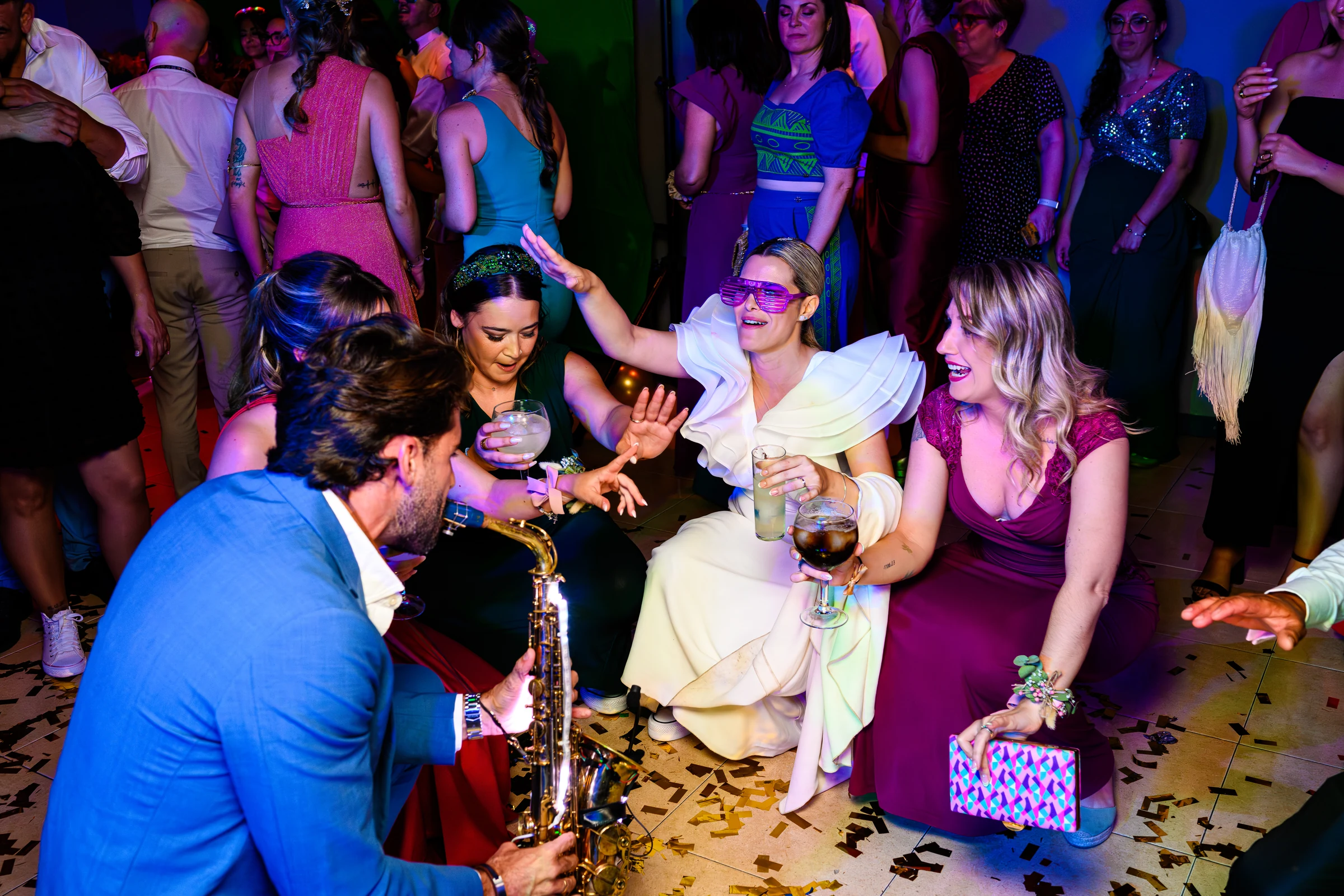 La novia celebra con sus invitados junto a un saxofonista durante la fiesta